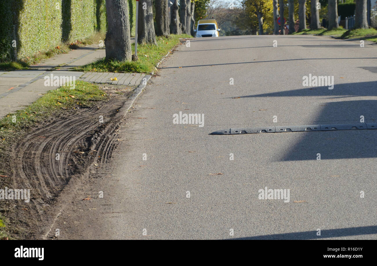 Speed bump being avoided via the roadside Stock Photo