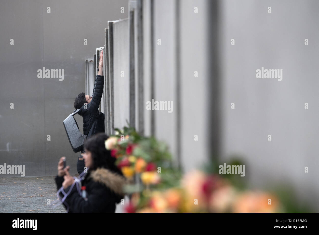 Berlin, Germany. 09th Nov, 2018. People place roses at the Berlin Wall Memorial during a commemoration ceremony marking the 29th anniversary of the Berlin Wall fall. Credit: Ralf Hirschberger/dpa/Alamy Live News Stock Photo