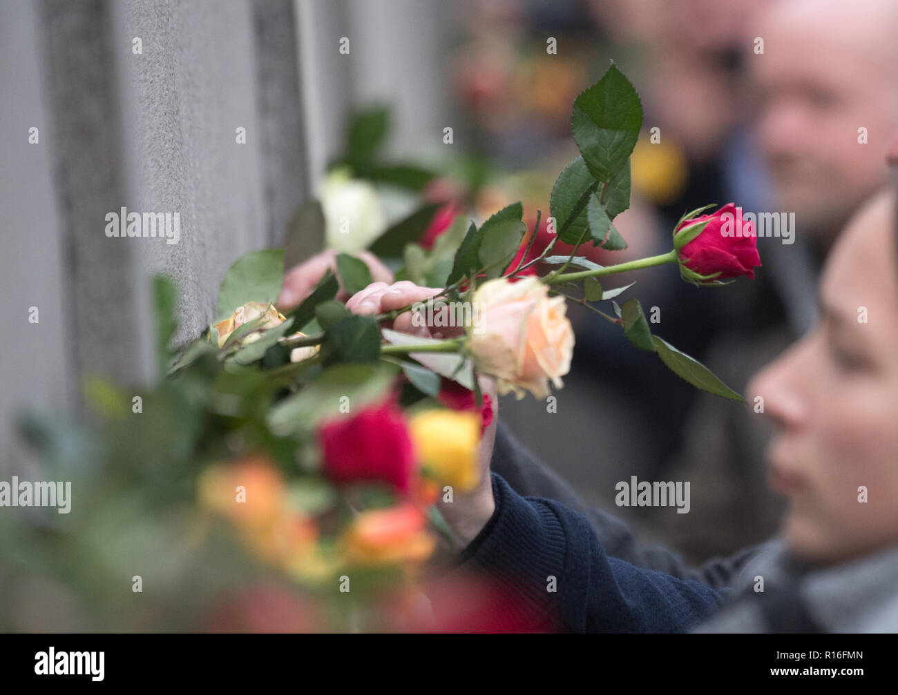 Berlin, Germany. 09th Nov, 2018. People place roses at the Berlin Wall Memorial during a commemoration ceremony marking the 29th anniversary of the Berlin Wall fall. Credit: Ralf Hirschberger/dpa/Alamy Live News Stock Photo