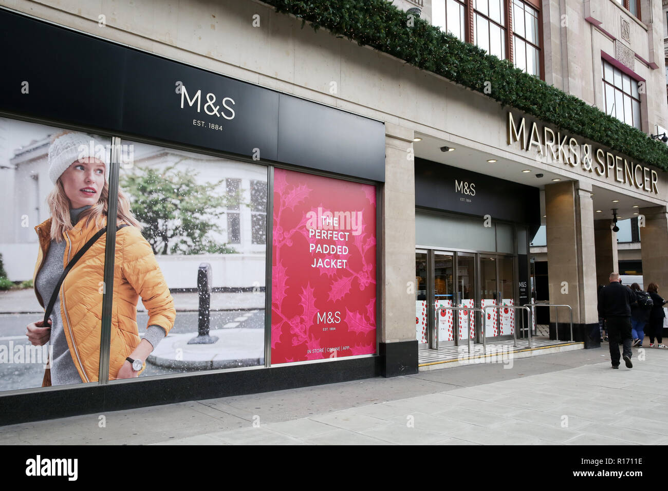 Shoppers are seen outside Marks and Spencer store on London's Oxford Street. The retail sector faces difficulties as consumers cut down on spending and do more of their shopping online. A report by accountancy firm PWC has said that over 1,000 stores disappeared from Britain's top 500 high streets in the first six months of the year. Stock Photo