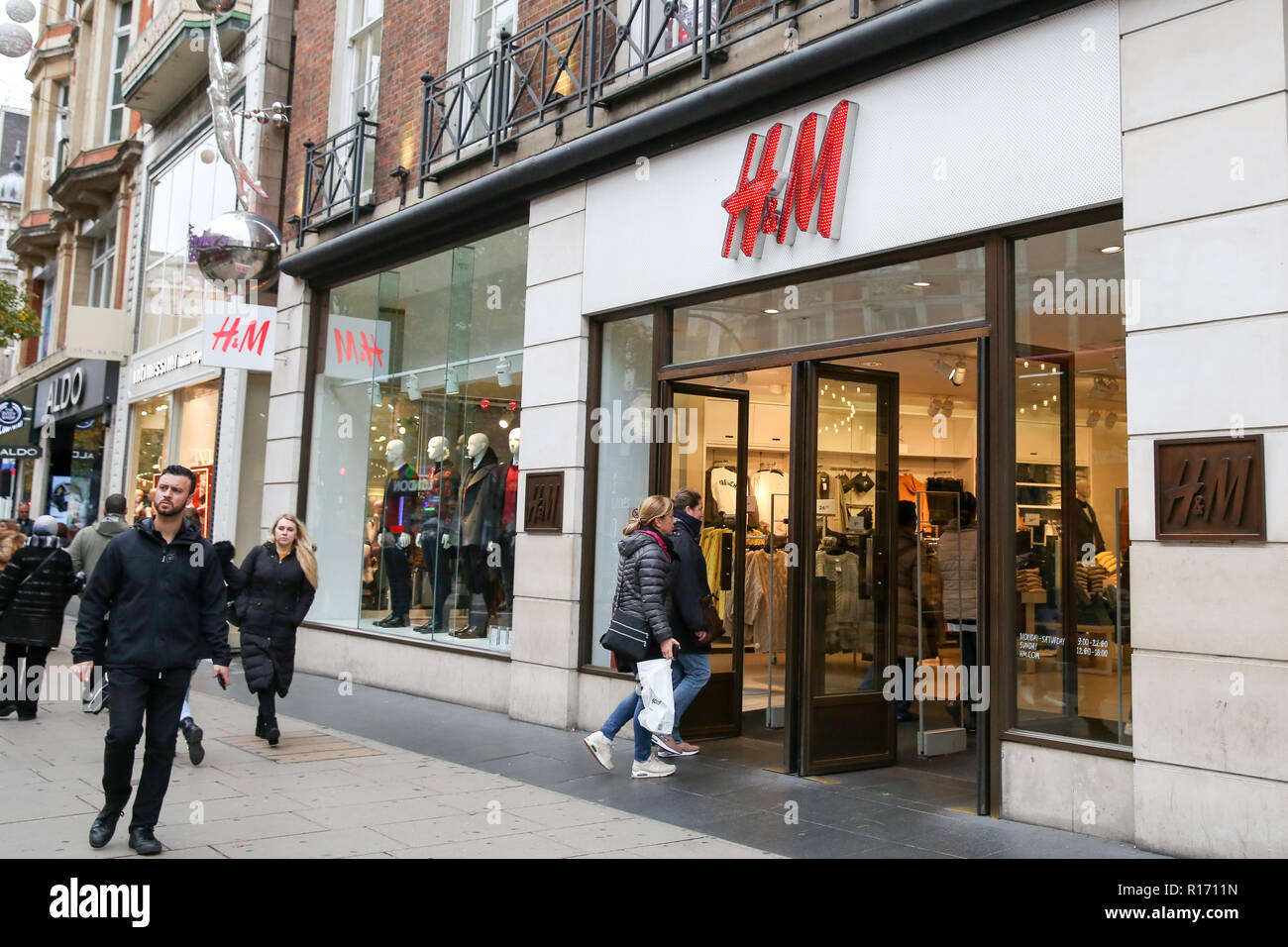 Shoppers are seen outside H&M store on London's Oxford Street. The retail sector faces difficulties as consumers cut down on spending and do more of their shopping online. A report by accountancy firm PWC has said that over 1,000 stores disappeared from Britain's top 500 high streets in the first six months of the year. Stock Photo