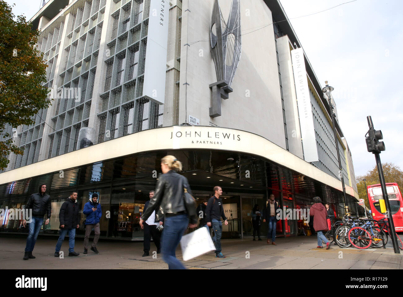 Shoppers are seen outside John Lewis store on London's Oxford Street. The retail sector faces difficulties as consumers cut down on spending and do more of their shopping online. A report by accountancy firm PWC has said that over 1,000 stores disappeared from Britain's top 500 high streets in the first six months of the year. Stock Photo