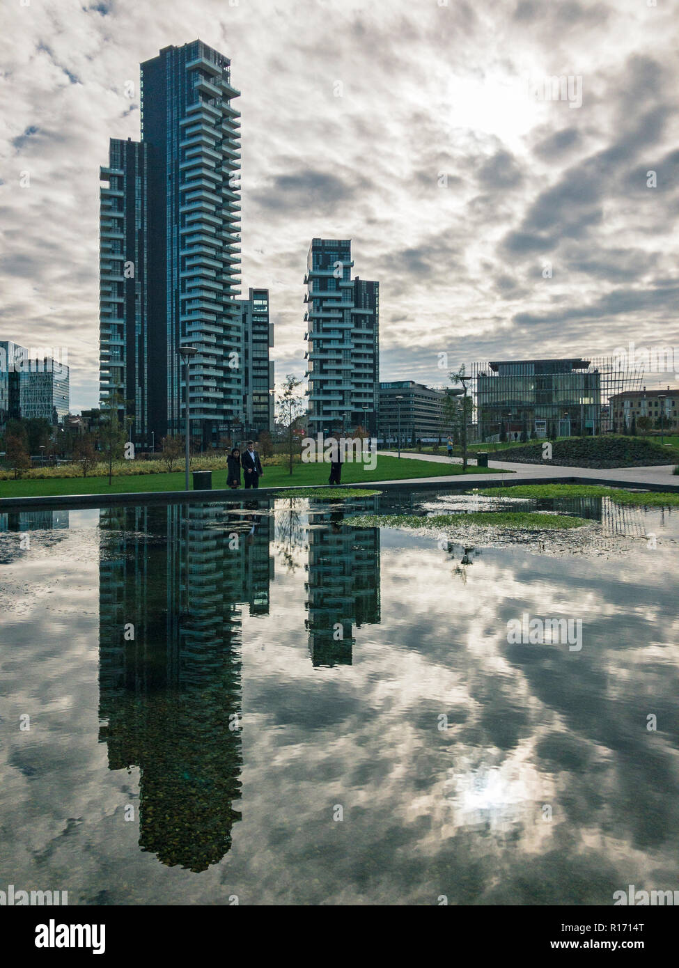 Library of trees, new Milan park. Solaria tower. Paths of the park with a panoramic view of the skyscrapers, Italy. Tower mirrored in the fountain Stock Photo