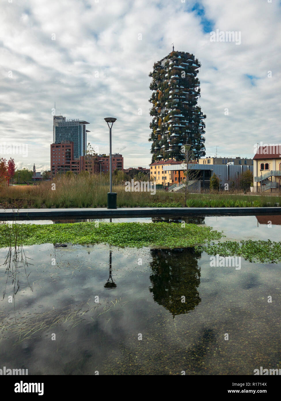 Library of trees, new Milan park. Vertical forest, Bosco verticale. Paths of the park. Italy. Skyscrapers mirrored in the fountain Stock Photo