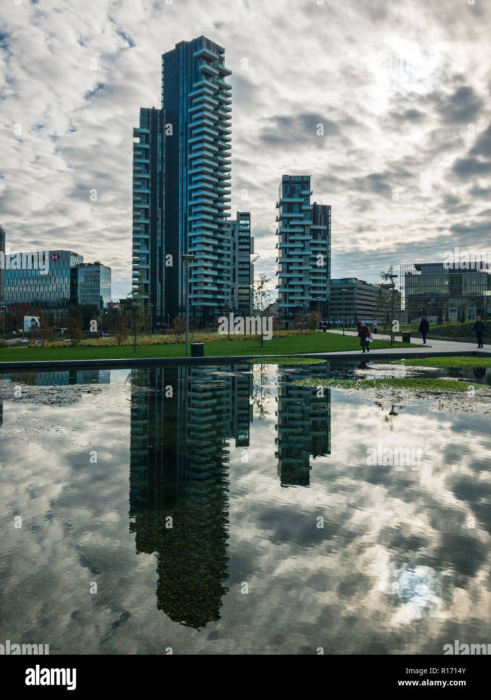 Library of trees, new Milan park. Solaria tower. Paths of the park with a panoramic view of the skyscrapers, Italy. Tower mirrored in the fountain Stock Photo