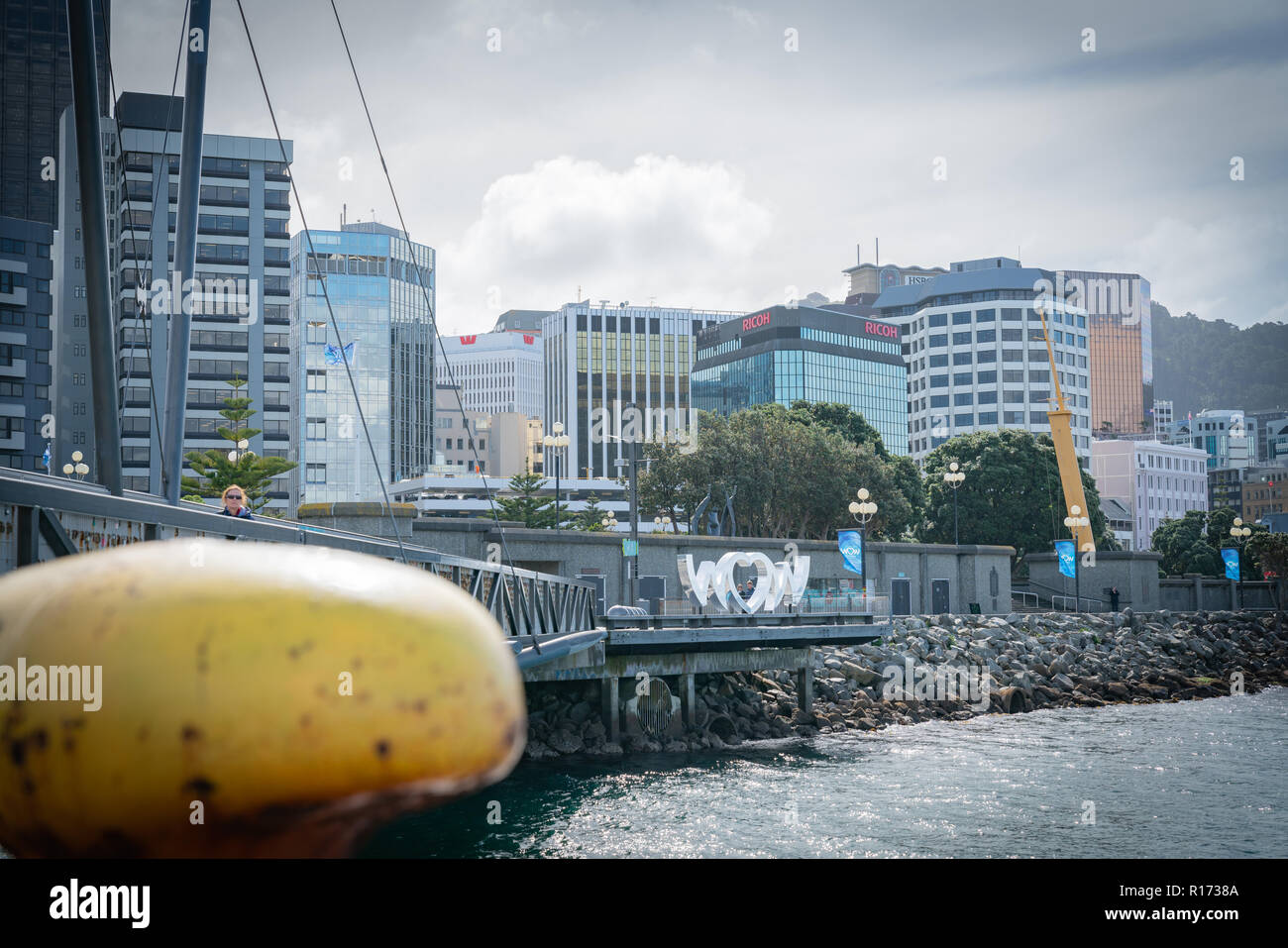 WELLINGTON, NEW ZEALAND - OCTOBER 1 2018; World of Wearable Art iconic shiny silver sign on city waterfront with cuty commercial skyline behind. Stock Photo