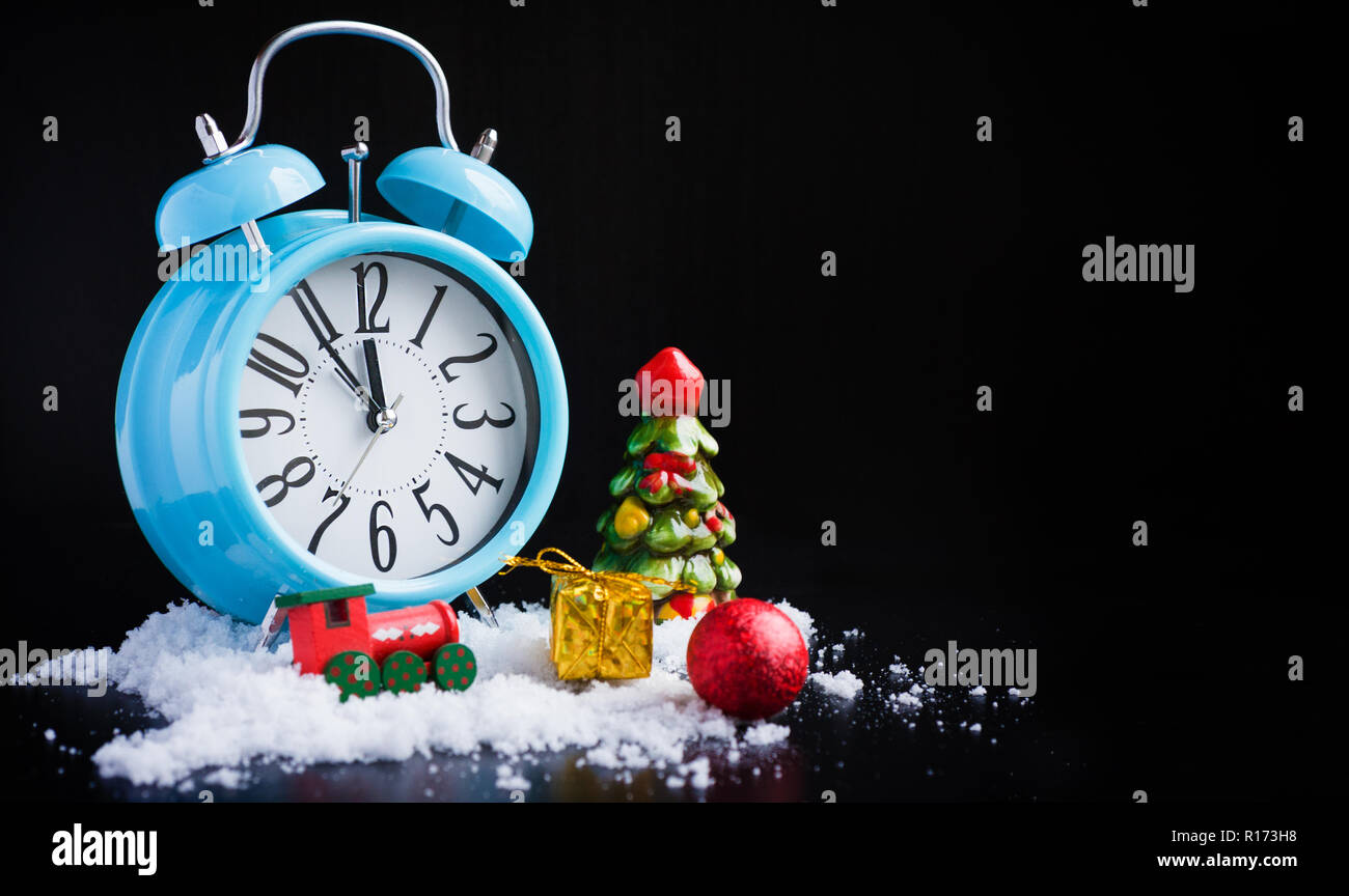 Alarm clock and new year decorations on black Stock Photo