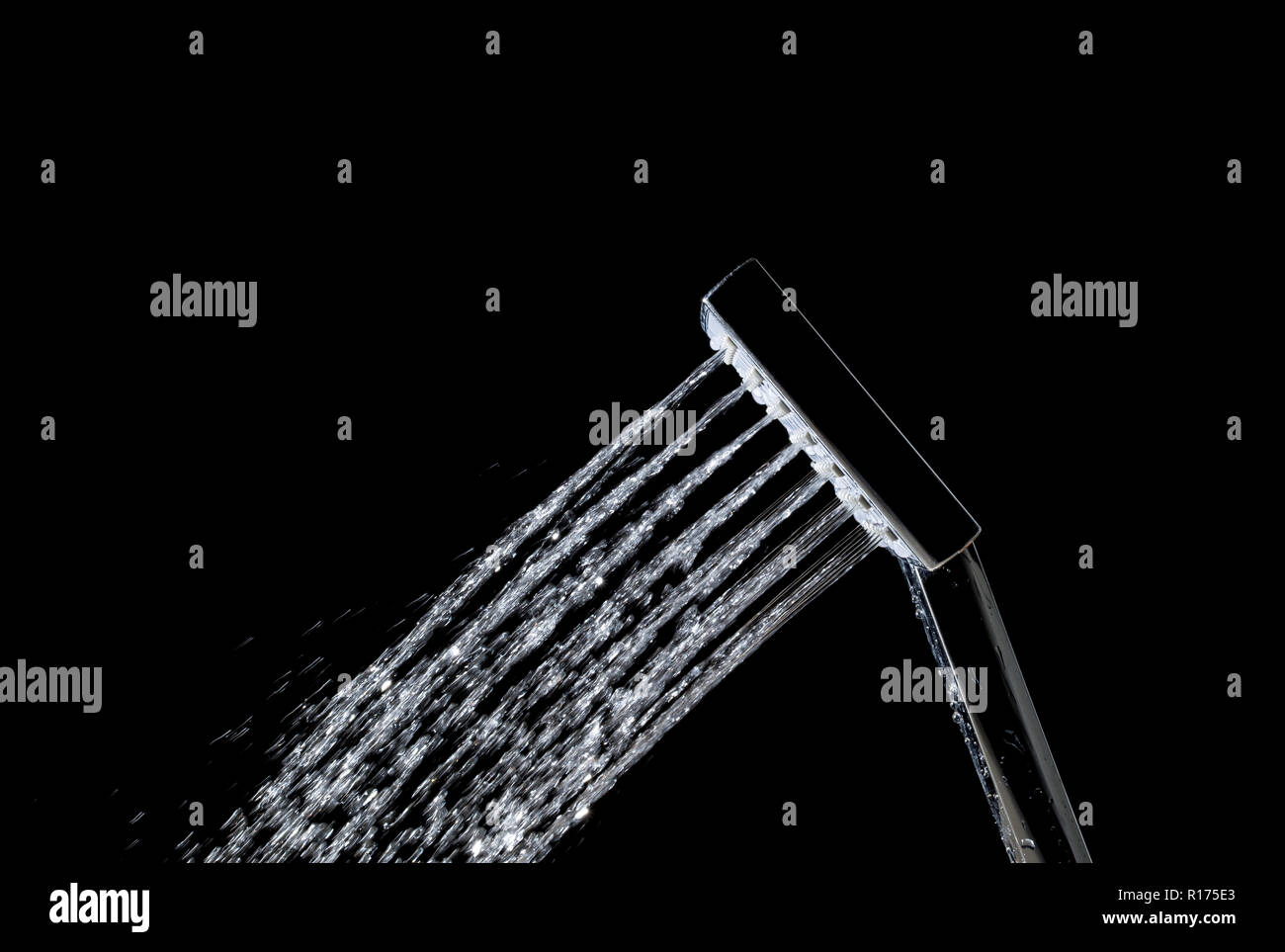 Modern hot shower with stream of water closeup isolated on black