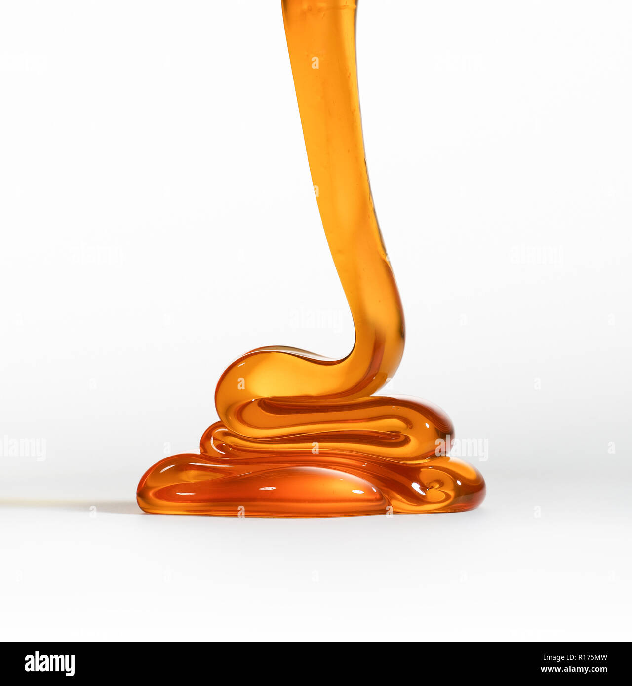 Pouring honey on white background Stock Photo