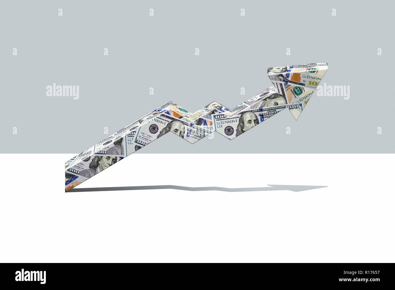 Arrow made from US dollars pointing upwards, grey background Stock Photo