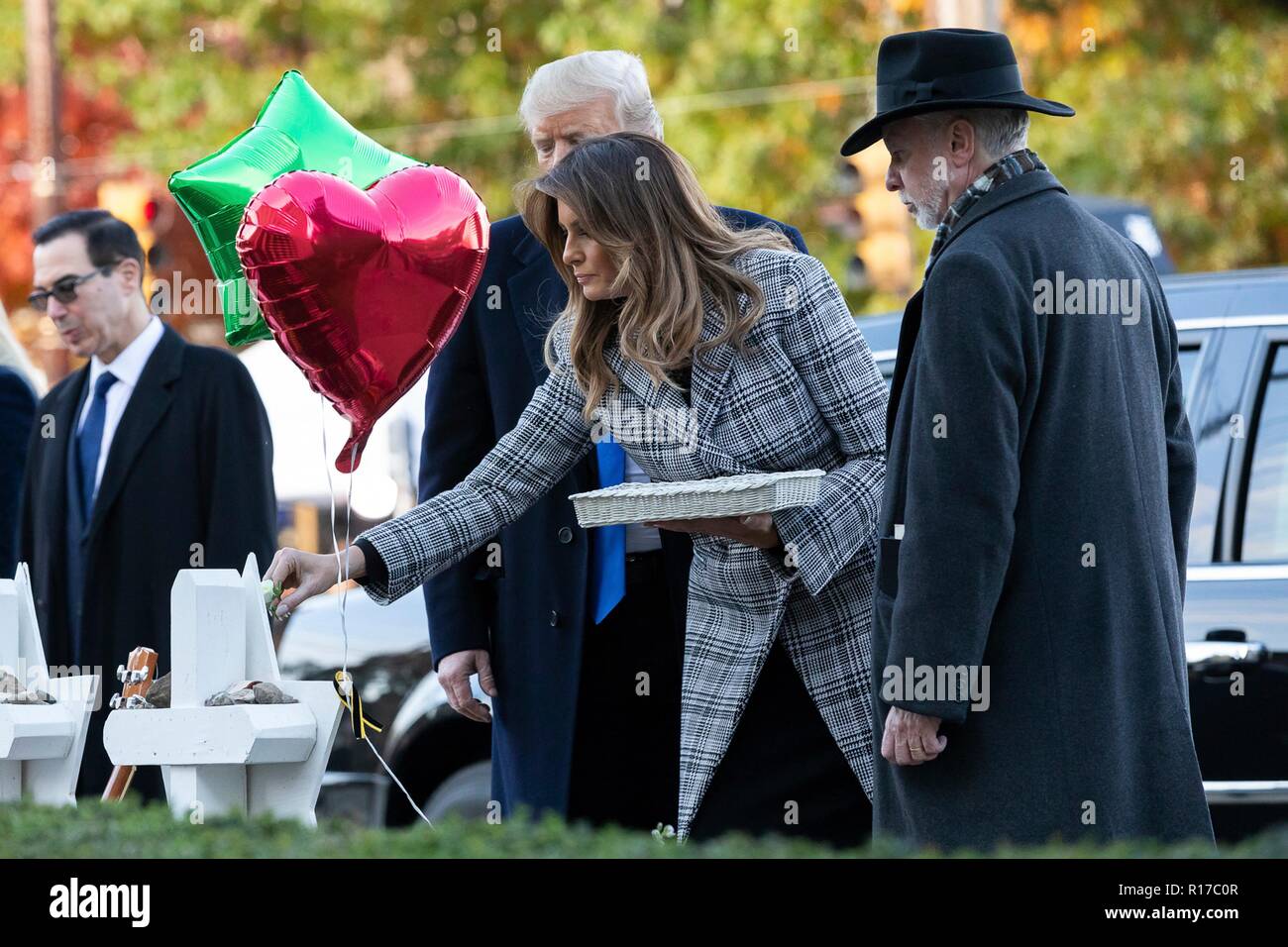 U.S first lady Melania Trump, place a white rose on the memorial of those killed at the Tree of Life Synagogue as President Donald Trump and Rabbi Jeffrey Myers, right, look on October 30, 2018 in Pittsburgh, Pennsylvania. Stock Photo