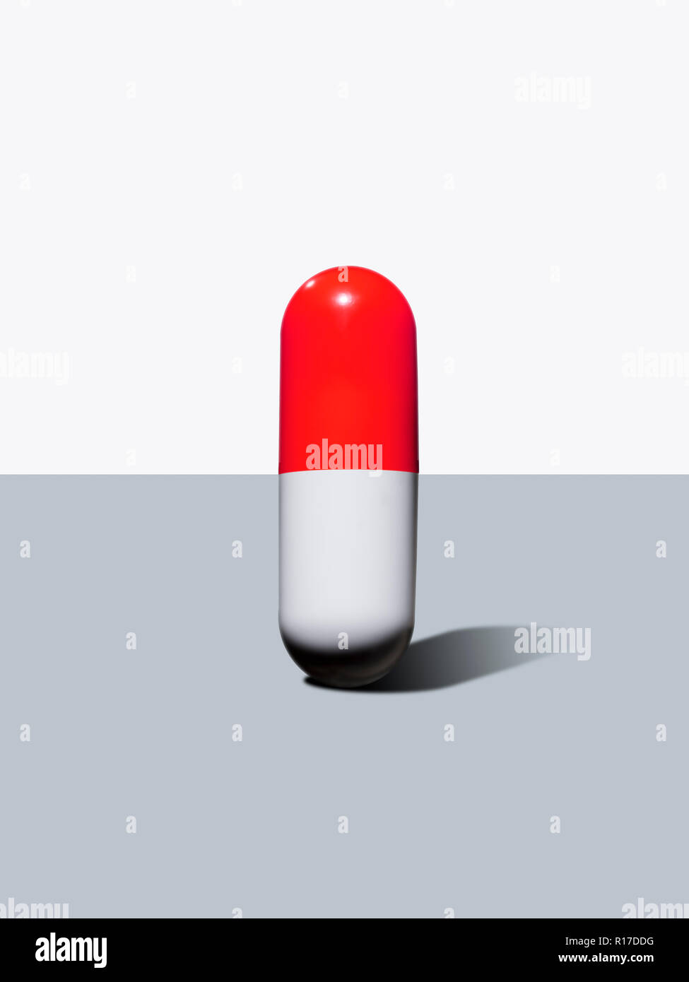 Upright red and white medication pill capsule, still life Stock Photo