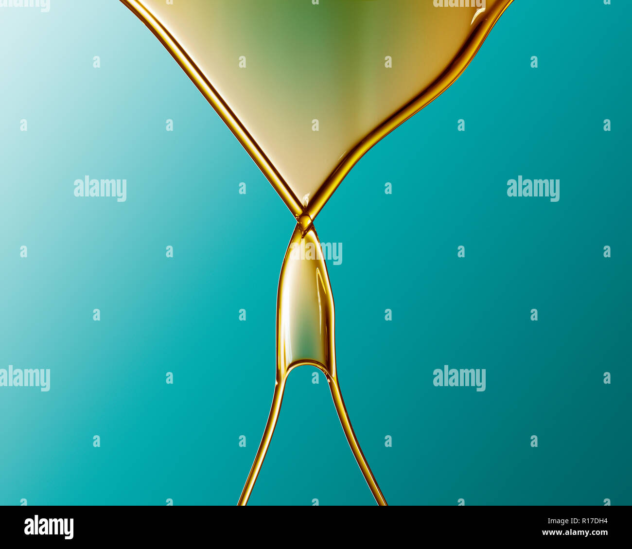Golden coloured oil flowing into V shape and crossing over against blue background Stock Photo