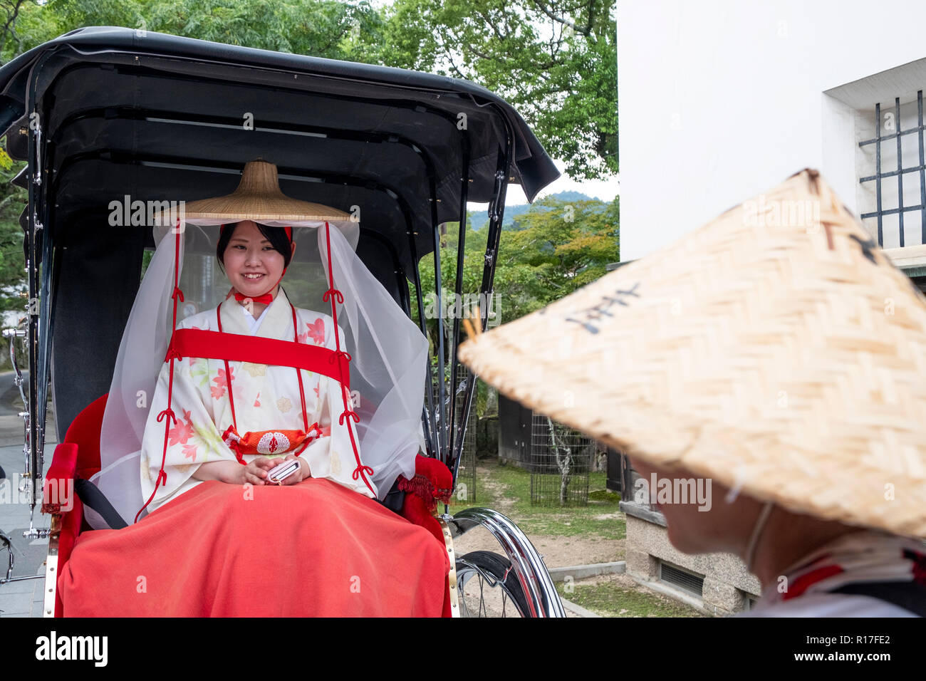 A Japanese tourist in traditional costume on Itsukushima, also known as Miyajima, an island in Hiroshima Bay, Japan Stock Photo