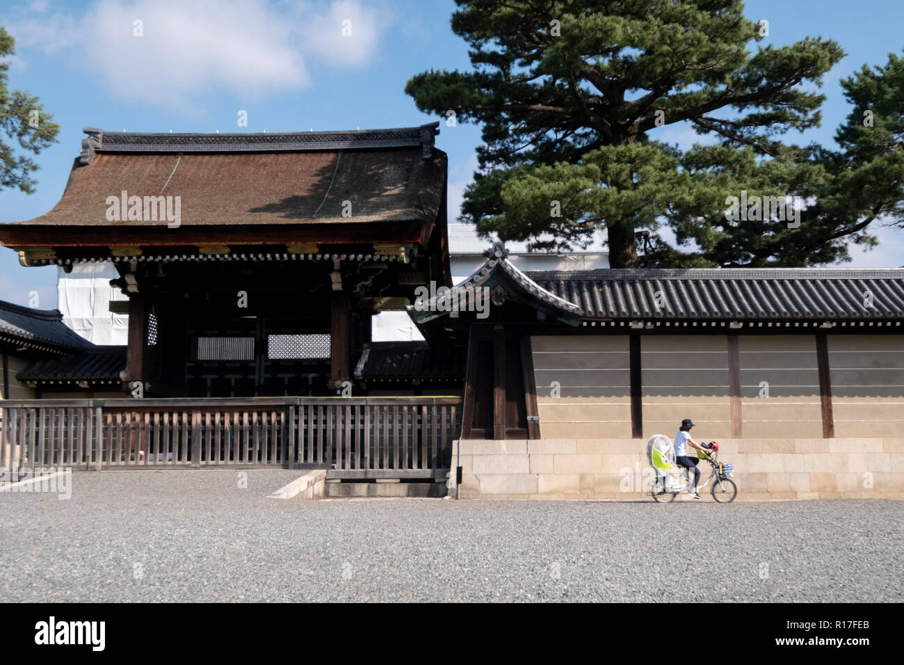 Cyclists outside the gates of the imperial palace in Kyoto, Japan Stock Photo