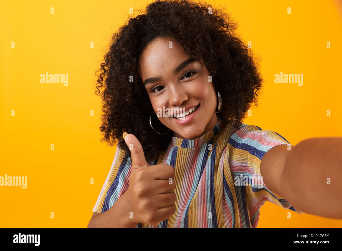 Image of beautiful young happy african cute girl posing isolated over  yellow background take a selfie with thumbs up gesture Stock Photo - Alamy, image size:1300x956