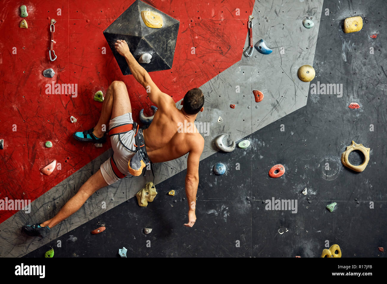 Male professional climber at indoor workout at bouldering centre. Stock Photo