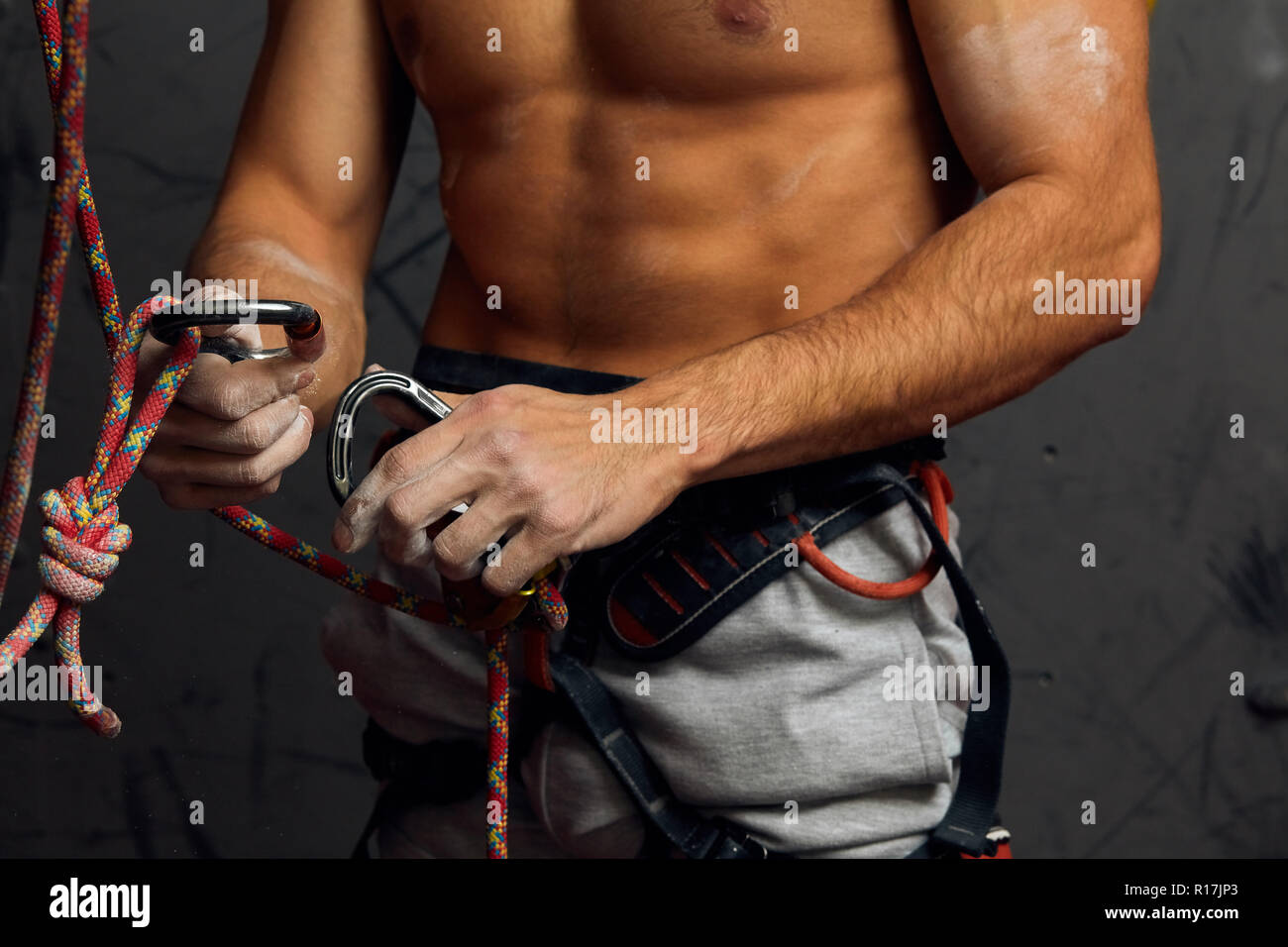 Climber s male hands with equipment during preparation for climb, close-up. Stock Photo