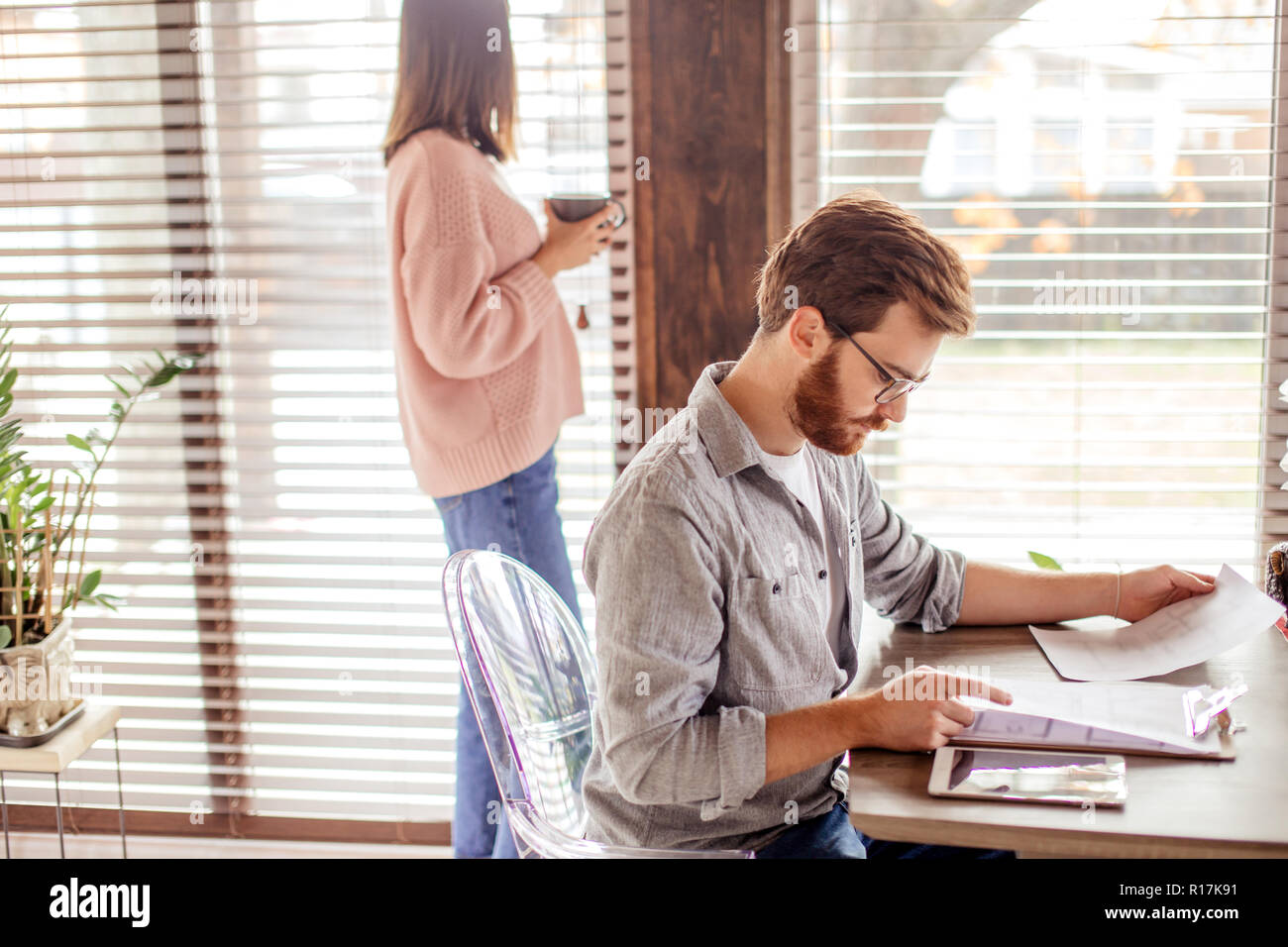 Young european man reading documents while sitting at table at home Stock Photo