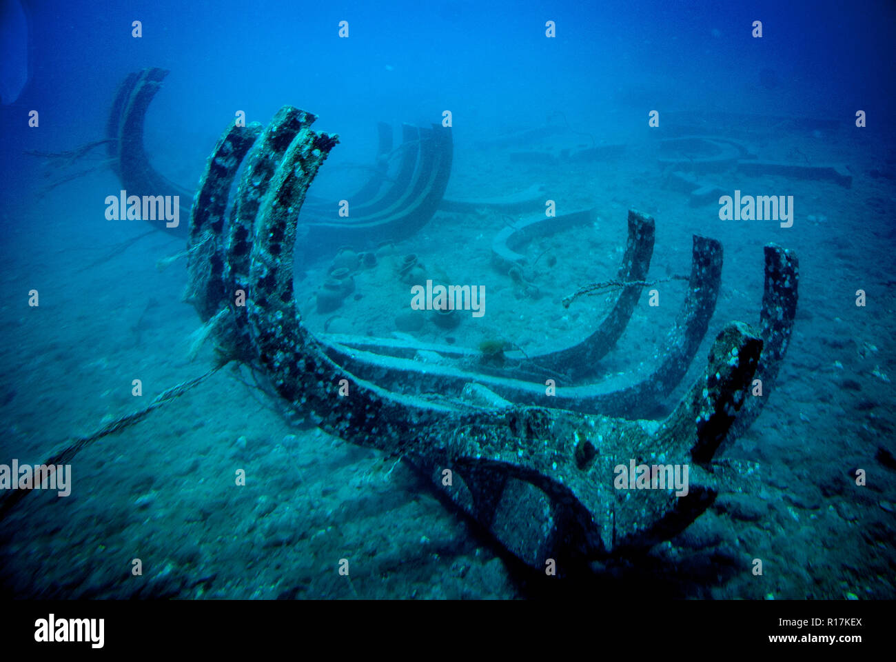 Pieces of ship wreck laying on the ground of the ocean in the blue water Stock Photo