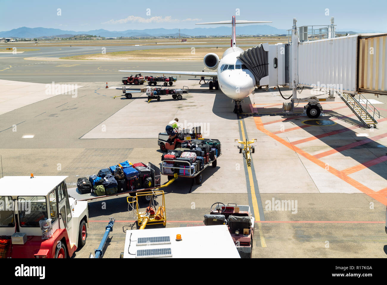 Crew preparing to load luggage onto plane in preparation for takeoff at Townsville airport, North Queensland, Australia Stock Photo