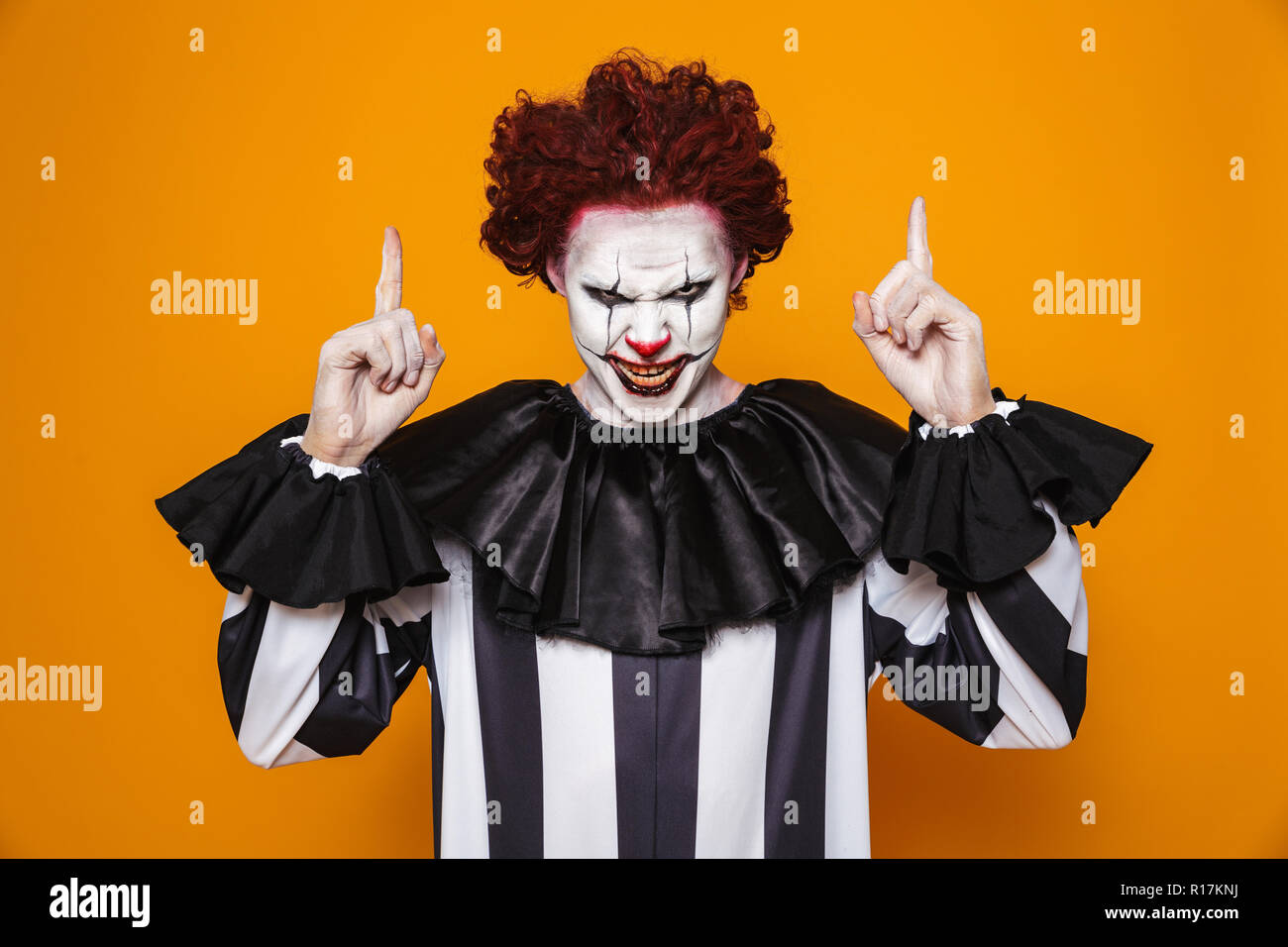 Scary Angry Man Clown With Red Hair Looking Camera And Pointing Up
