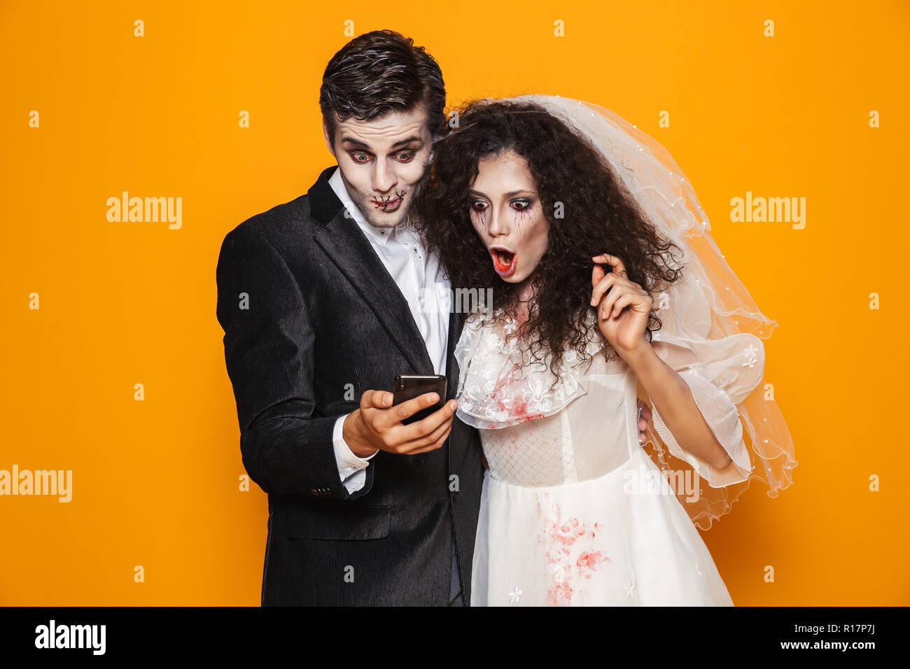Surprised Creepy Man And Woman In Halloween Wedding Costumes Using