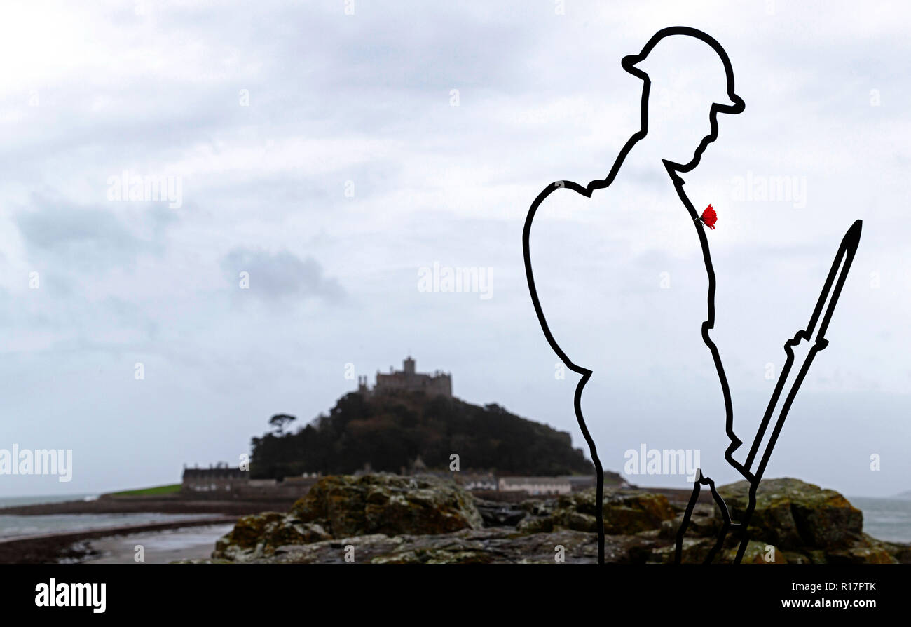 An installation for the Fallen.  A silhouette Tommy figure on Chapel Rock, in front of St Michael's Mount in Marazion, Cornwall, as part of There but  Stock Photo