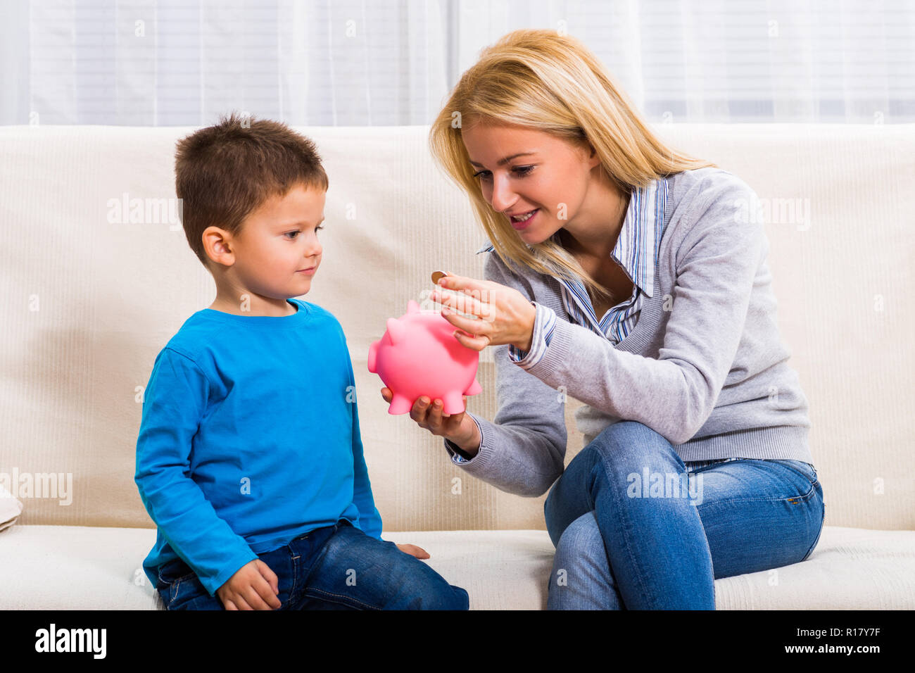 Happy mother and son are holding piggy bank Stock Photo - Alamy
