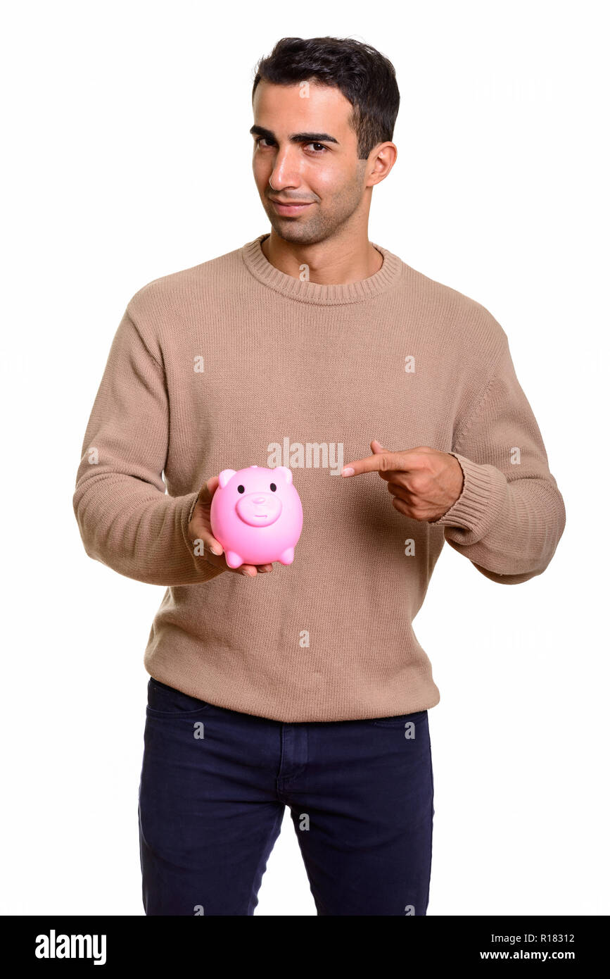 Portrait of young handsome Persian man with piggy bank Stock Photo