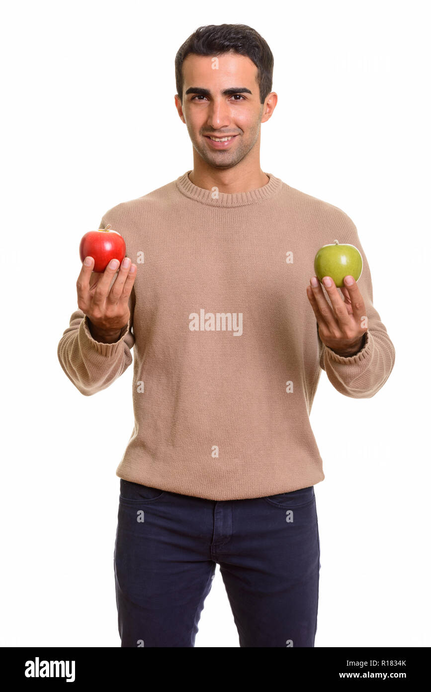 Handsome Persian man holding healthy green and red apple Stock Photo
