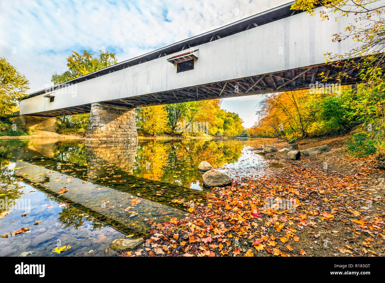 Potter's Covered Bridge crosses the West Fork of the White River surrounded by colorful fall foliage in Noblesville, Indiana. Stock Photo