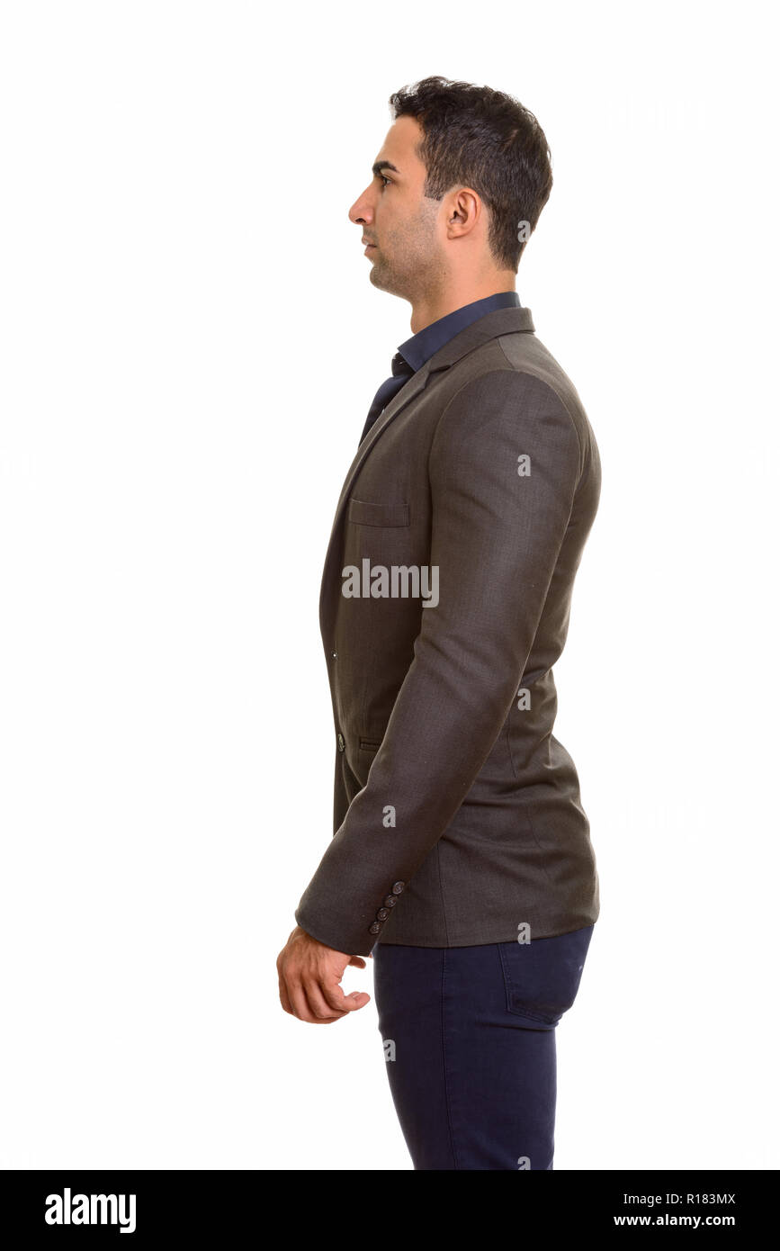 Profile view of young handsome Persian businessman standing Stock Photo
