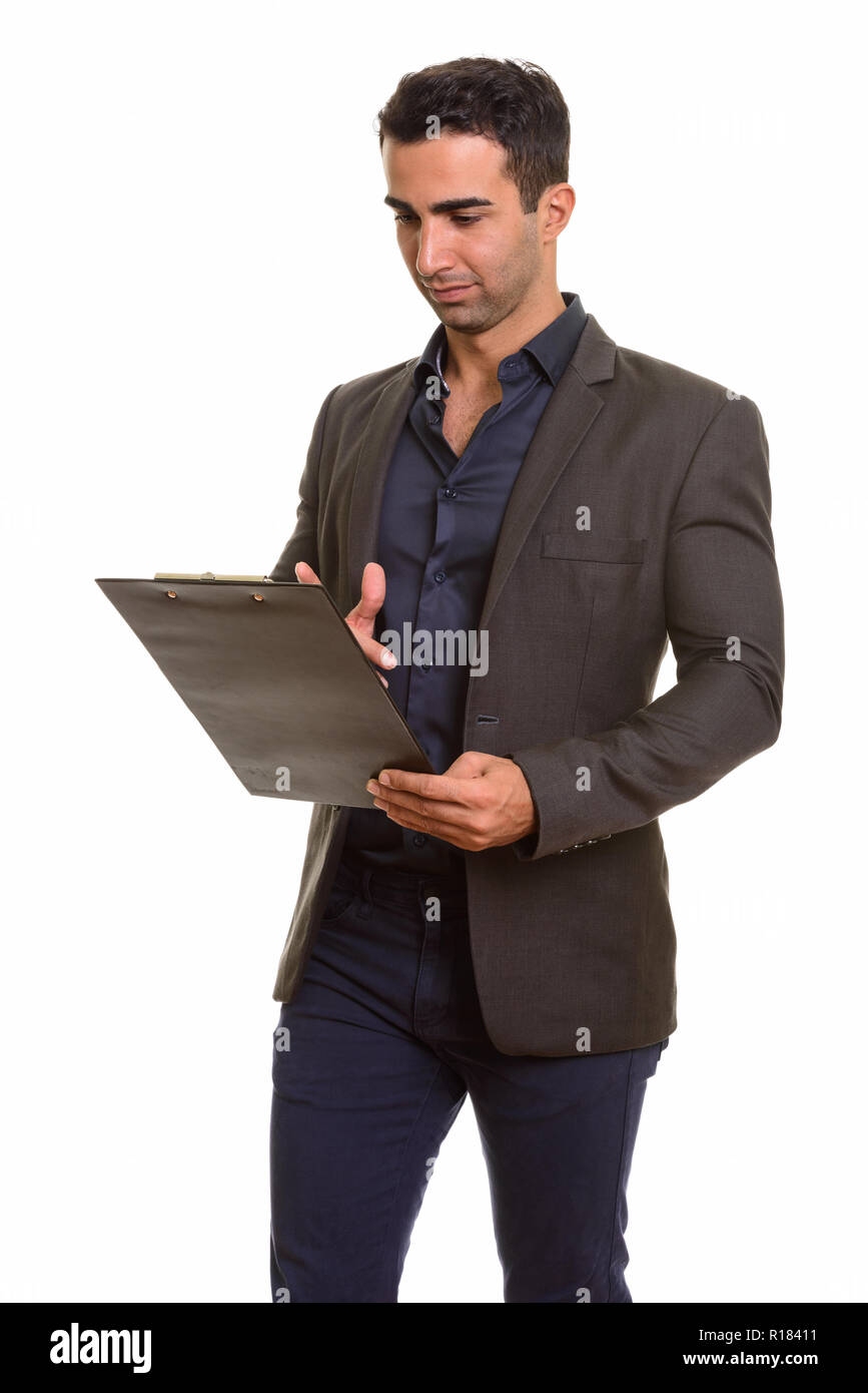 Portrait of young handsome Persian businessman with clipboard Stock Photo