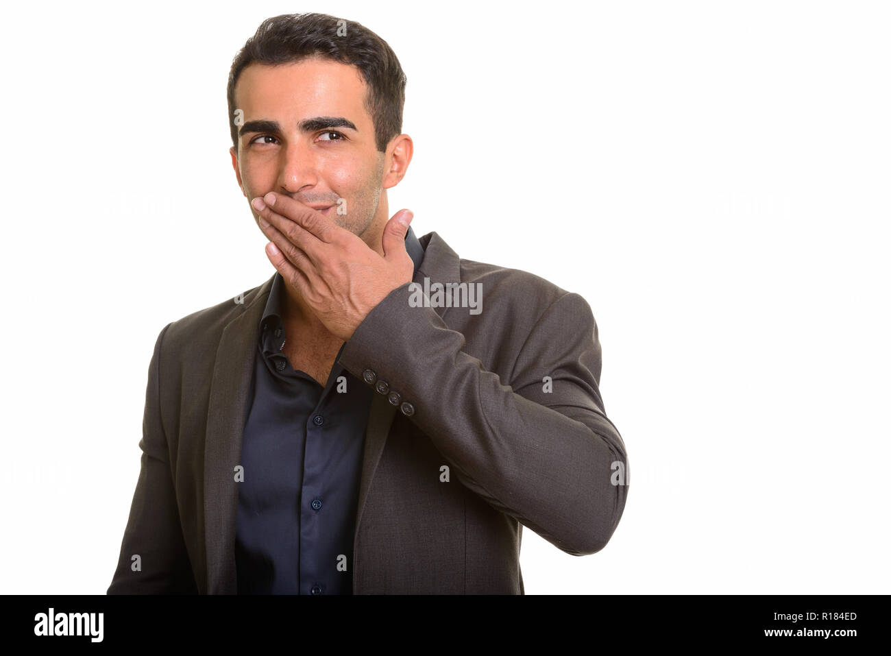 Portrait of young handsome Persian businessman laughing Stock Photo