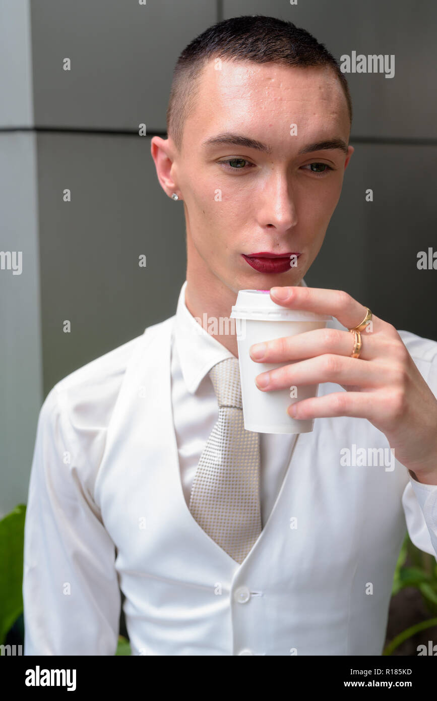Young androgynous homosexual LGTB businessman drinking coffee Stock Photo