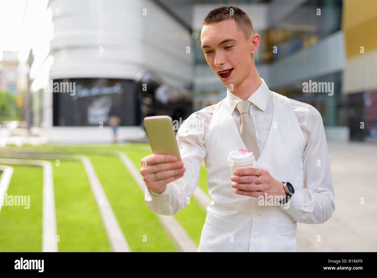 Young androgynous homosexual LGTB businessman using phone Stock Photo