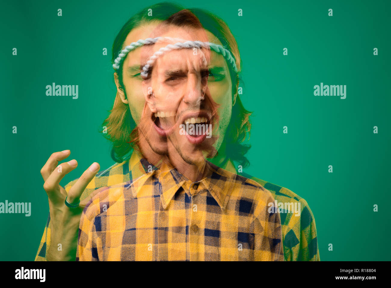 Studio shot of rebellious young man against green background Stock Photo
