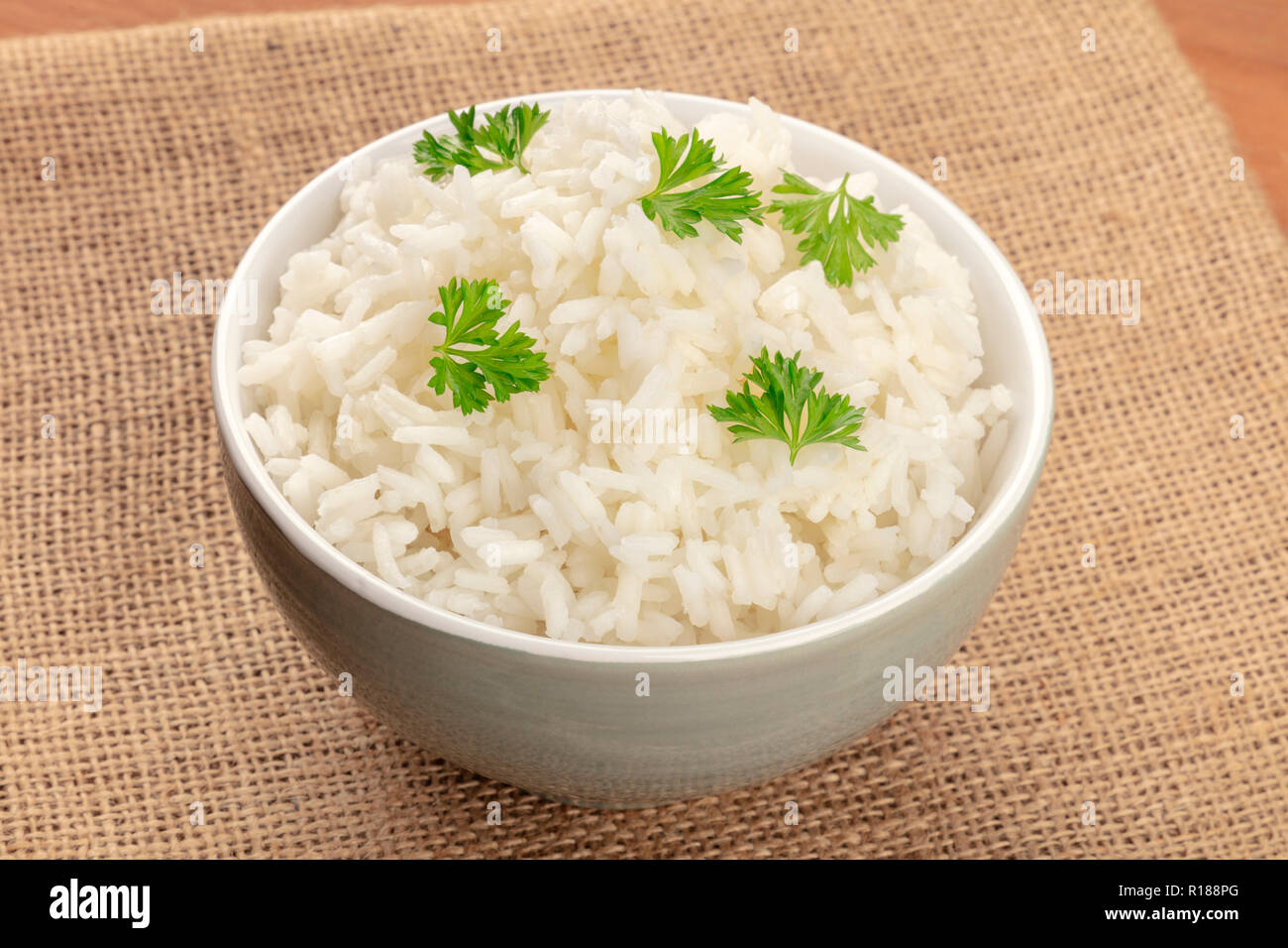 A photo of a bowl of cooked white long rice on rustic textures with ...
