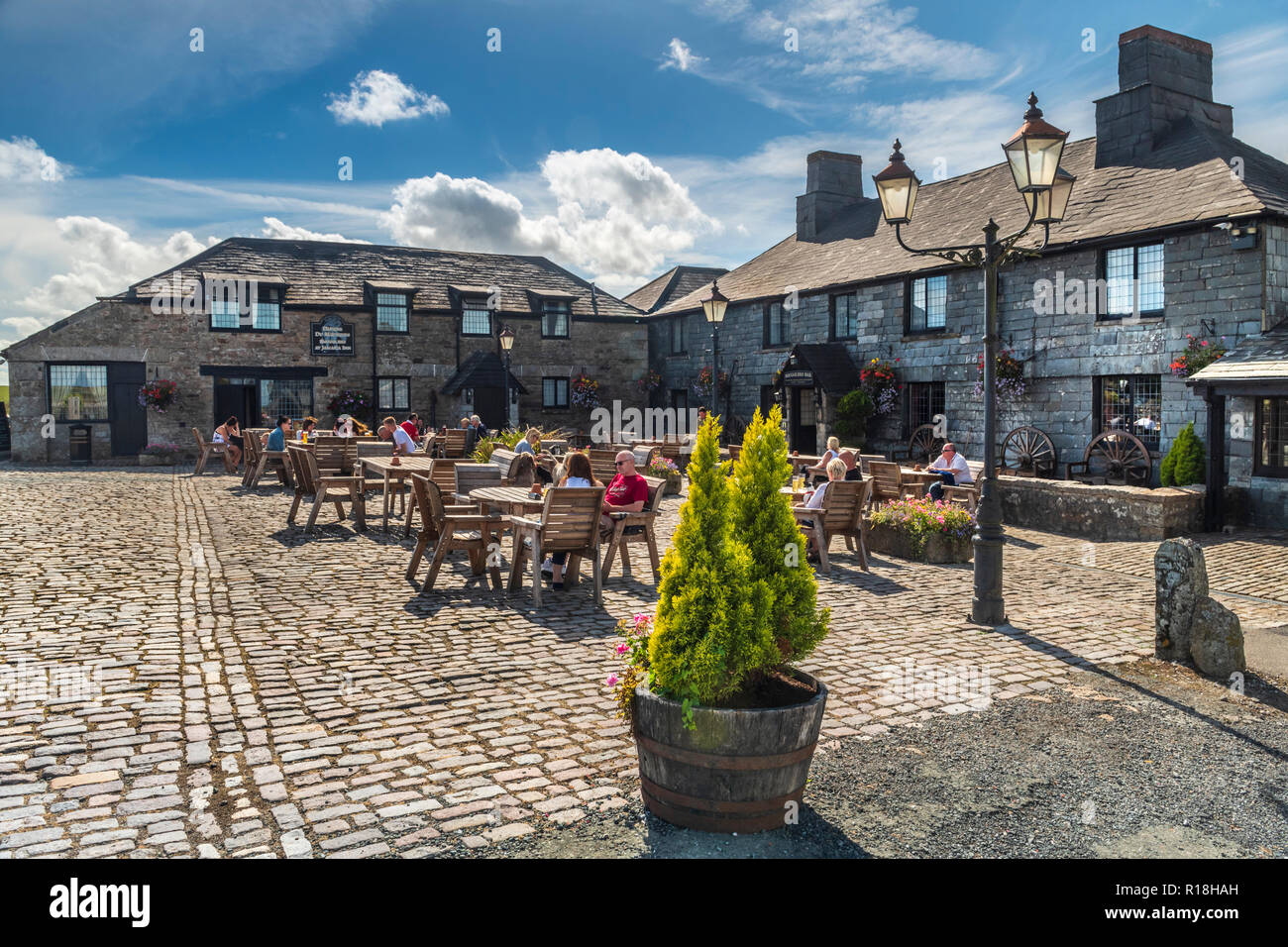 On a sunny day in August, people sit outside Jamaica Inn situated on Bodmin Moor, made famous by Daphne du Maurier in her novel of the same name. Stock Photo