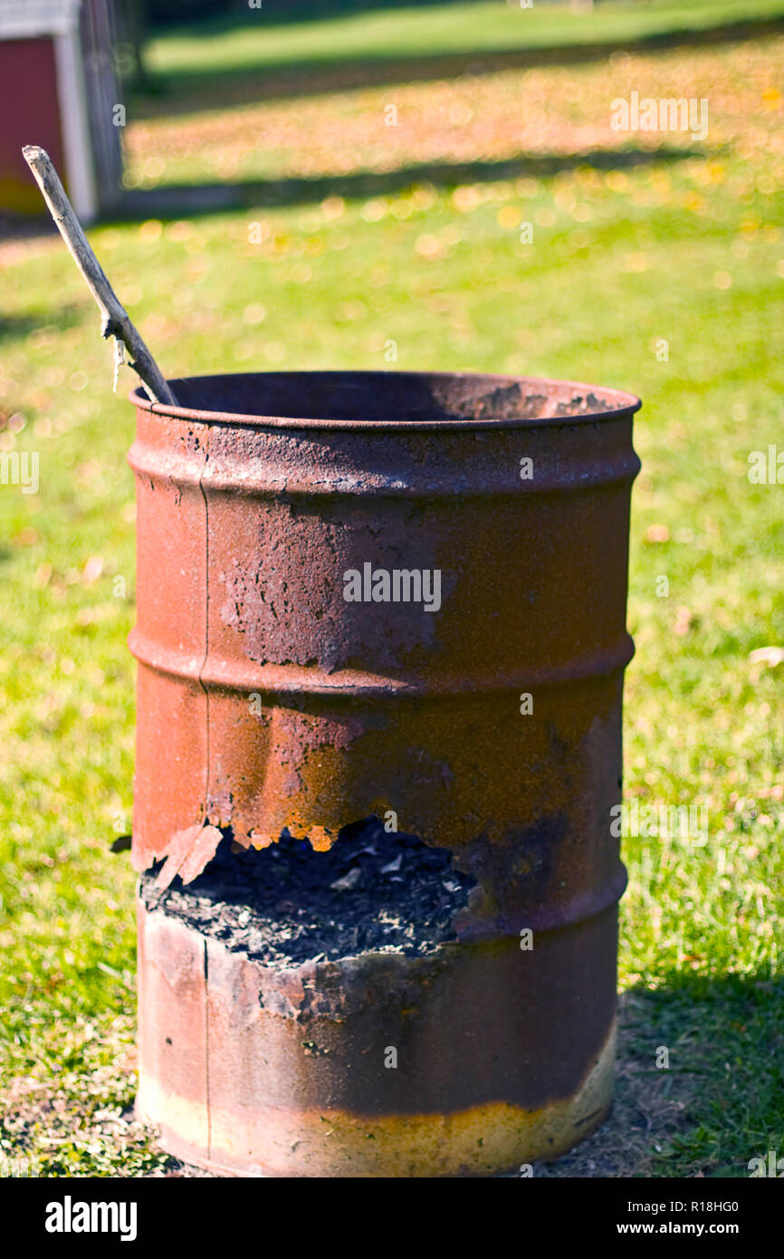 Old rusty container in backyard used to burn trash. Stock Photo