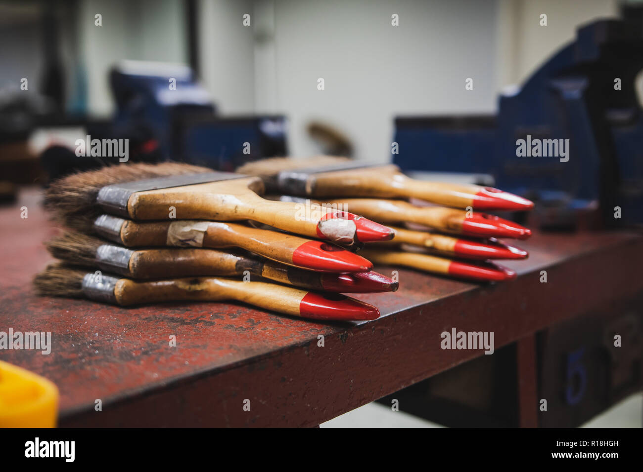 Bunch of paint brush on metal file workbench used to sweep out metal
