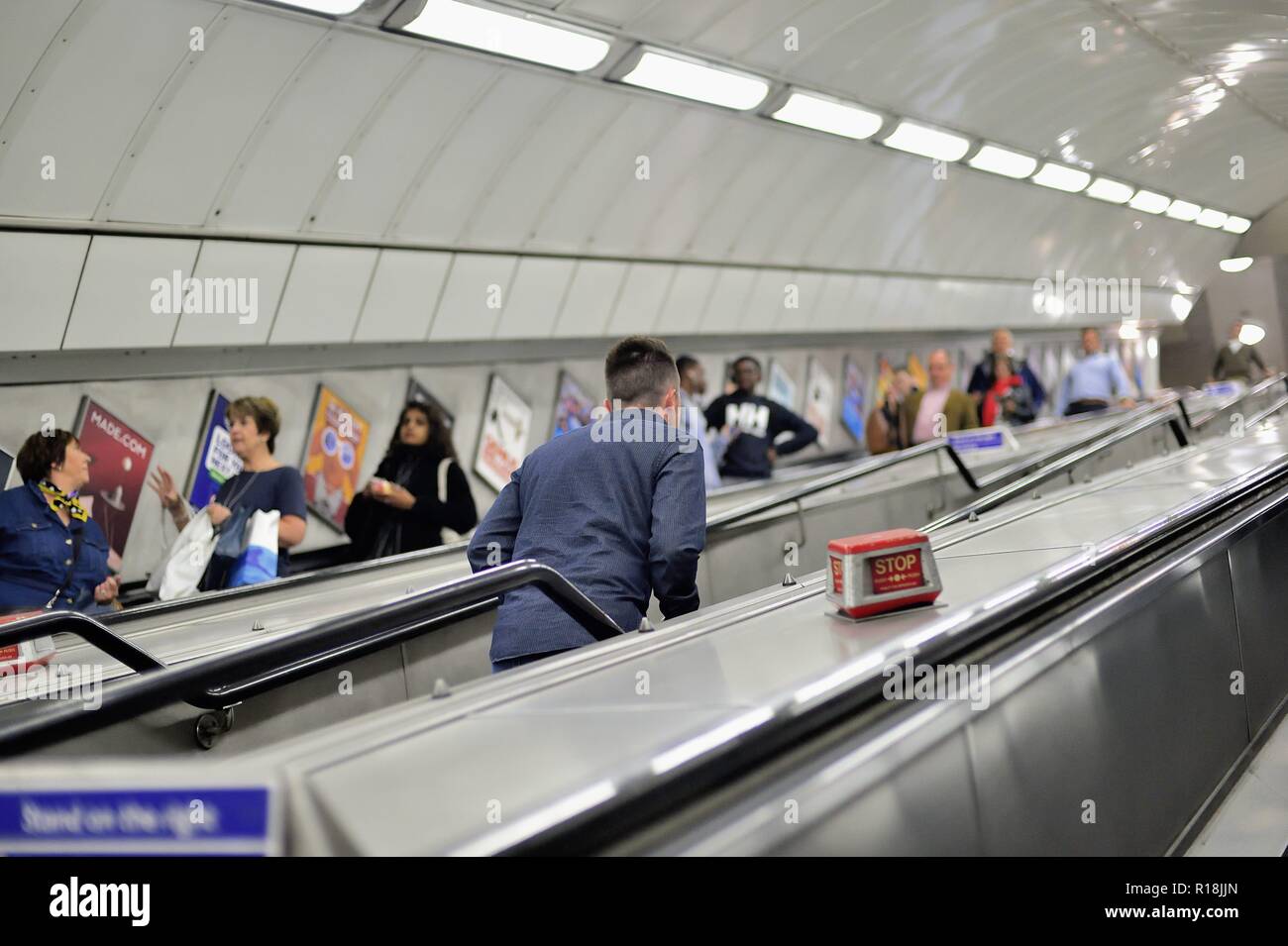 London, England, United Kingdom. At lest one person elects to make the long walk up the stairs while others ride the escalators. Stock Photo