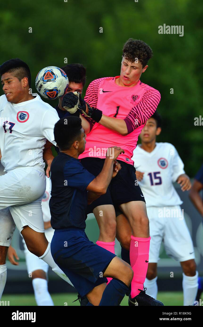 Keeper venturing into a bevy of activity in front of his net to ward off a possible shot and score. USA. Stock Photo