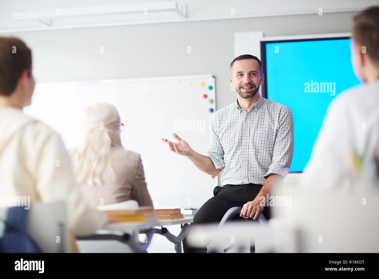 Happy confident teacher explaining his students what he thinks about ...