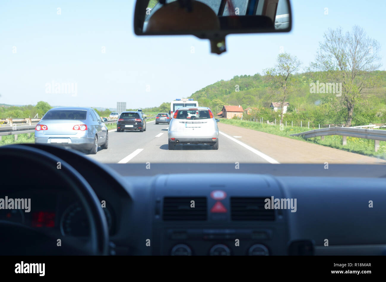 View through a windshield of a car on a highway and other vehicles on a
