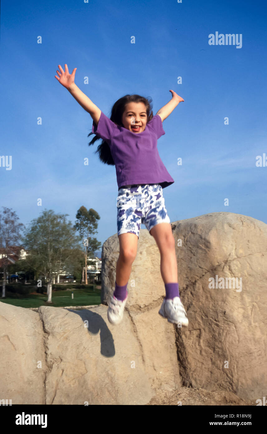 Young girl jumping from rock wall on playground. MR.  © Myrleen Pearson  ...Ferguson Cate Stock Photo