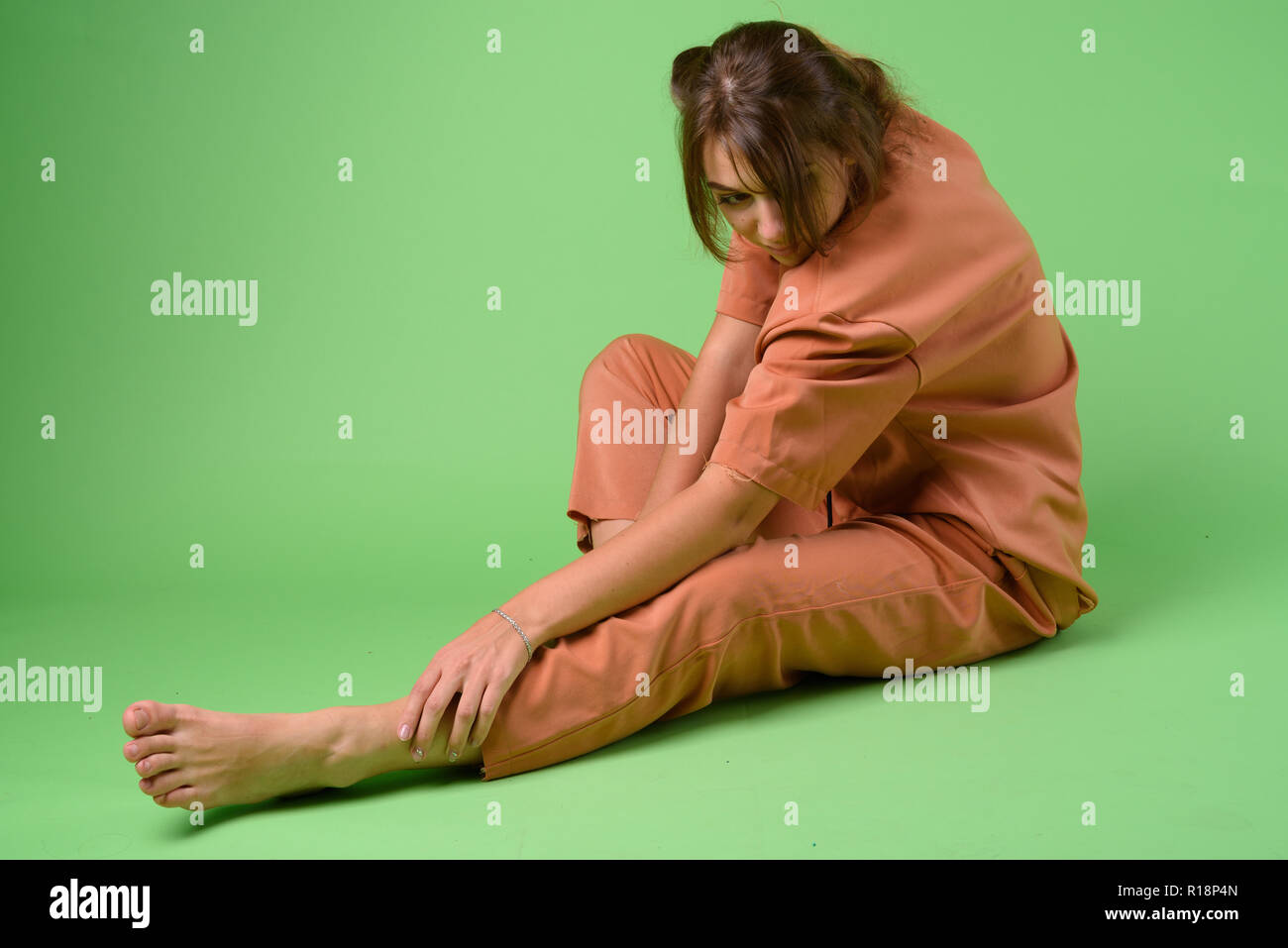 Studio shot of young beautiful woman against green background Stock Photo