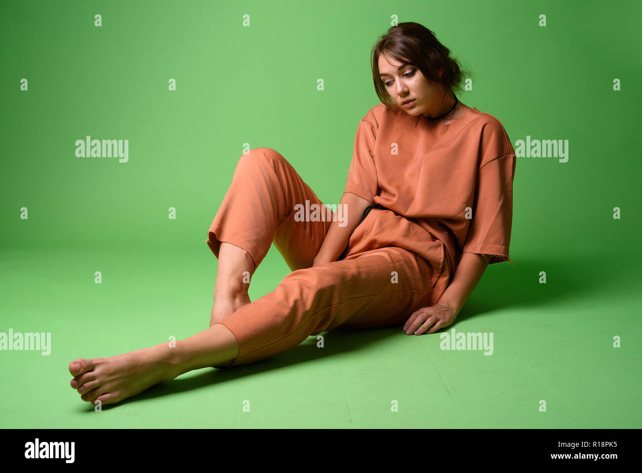 Studio shot of young beautiful woman against green background Stock Photo