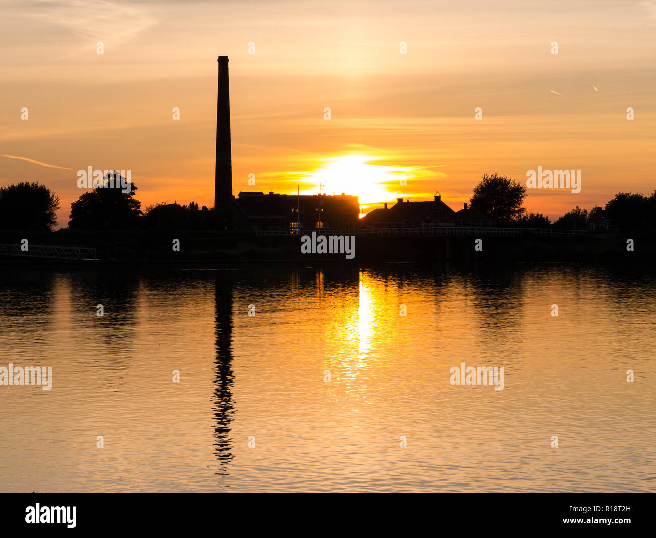 Waterfront silhouette of steam pumping station with museum at sunset, Medemblik, Noord-Holland, Netherlands Stock Photo
